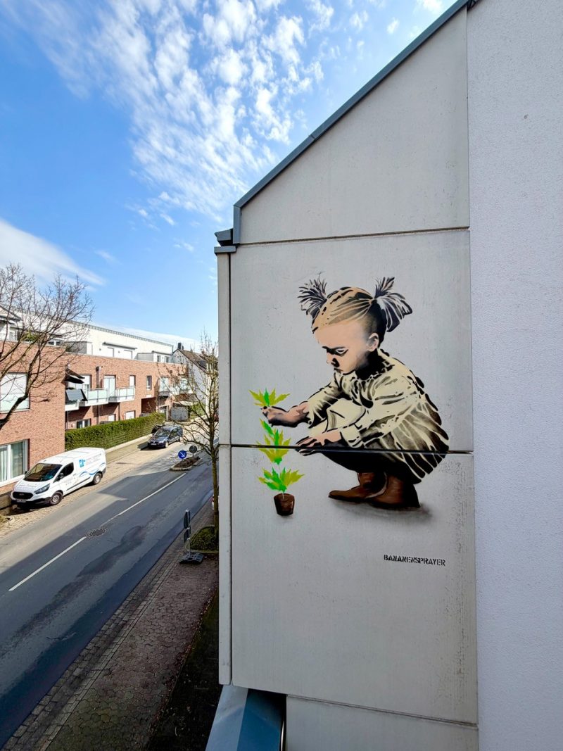 Mädchen mit Pflanze. Neues Wandbild von Thomas Baumgärtel am Niederrhein - 40 Jahre Bananensprayer - Kunst entdecken auf ARTTRADO Plattform für Kunst und Kultur.