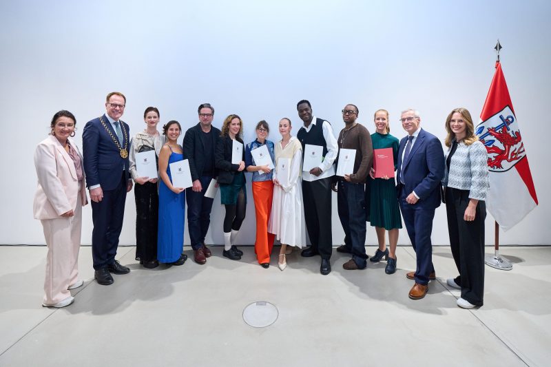 Oberbürgermeister Dr. Stephan Keller (2.v.l.) und Miriam Koch (l.), Beigeordnete für Kultur und Migration, mit den Kulturpreisträgerinnen und Kulturpreisträgern 2026. Mit dabei: Vorstandsvorsitzender der Stadtsparkasse Düsseldorf Dr. Stefan Dahm (2.v.r.) und Esther Breinig (r.), Kunst- und Kulturstiftung der Stadtsparkasse Düsseldorf. Kunst und Musik: Boondawg erhält Düsseldorfer Kulturpreis: Rapper gehört zu den neuen Kulturpreisträgern 2026 - Rap trifft kommunale Kulturförderung. Kunst entdecken auf ARTTRADO - Plattform für Kunst und Kultur.